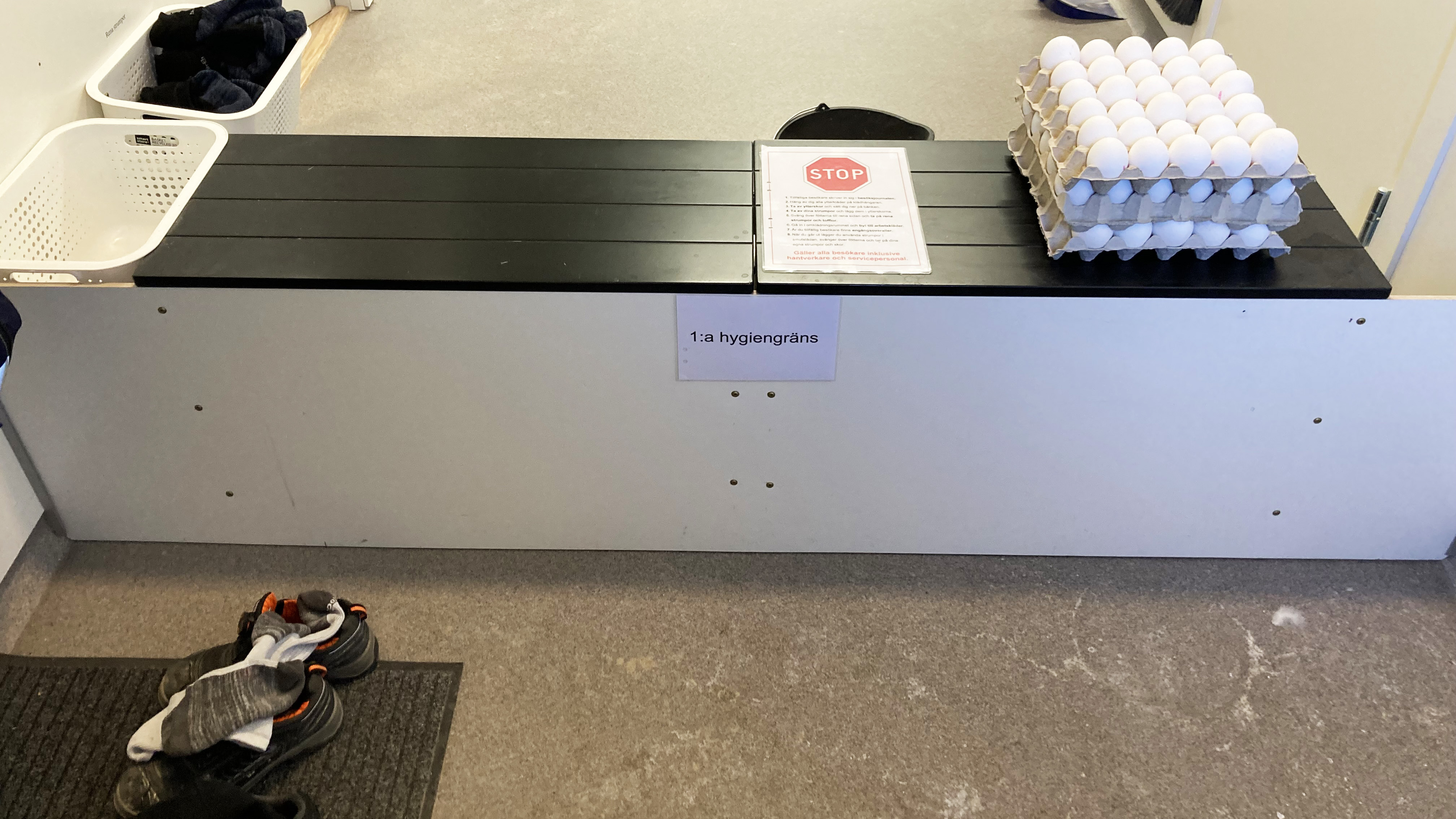 En barriär i en korridor. På barriären ligger bland annat en stoppskylt och ägg. Foto.