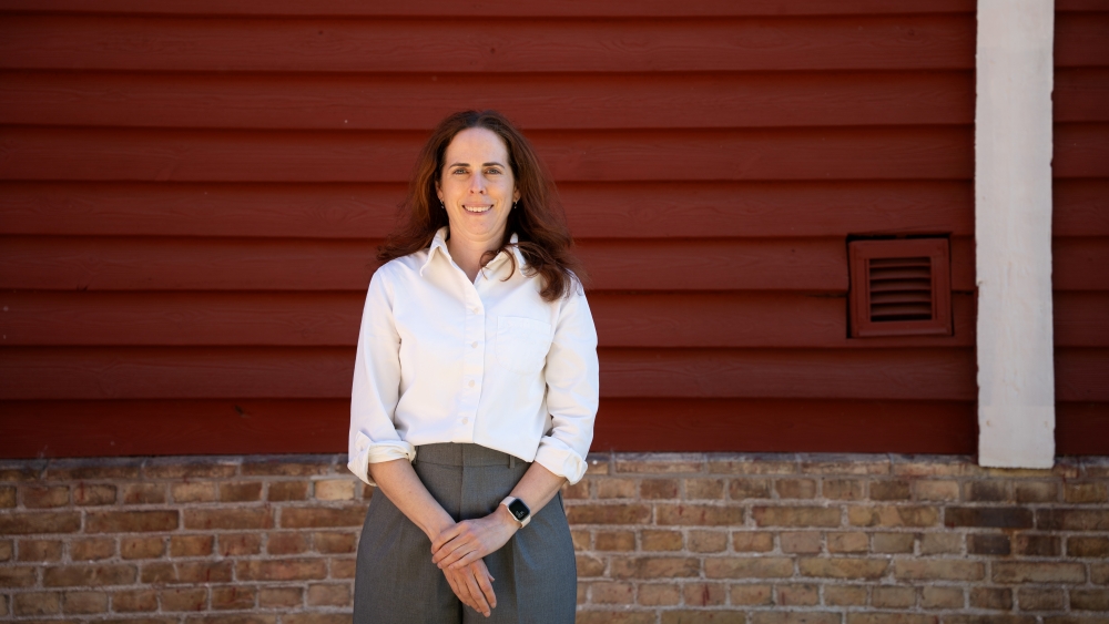 Portrait of Rebeka Zsoldos in front of a red wall.