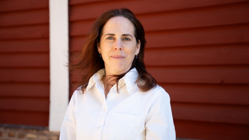 Portrait of Rebeka Zsoldos in front of a red wall.