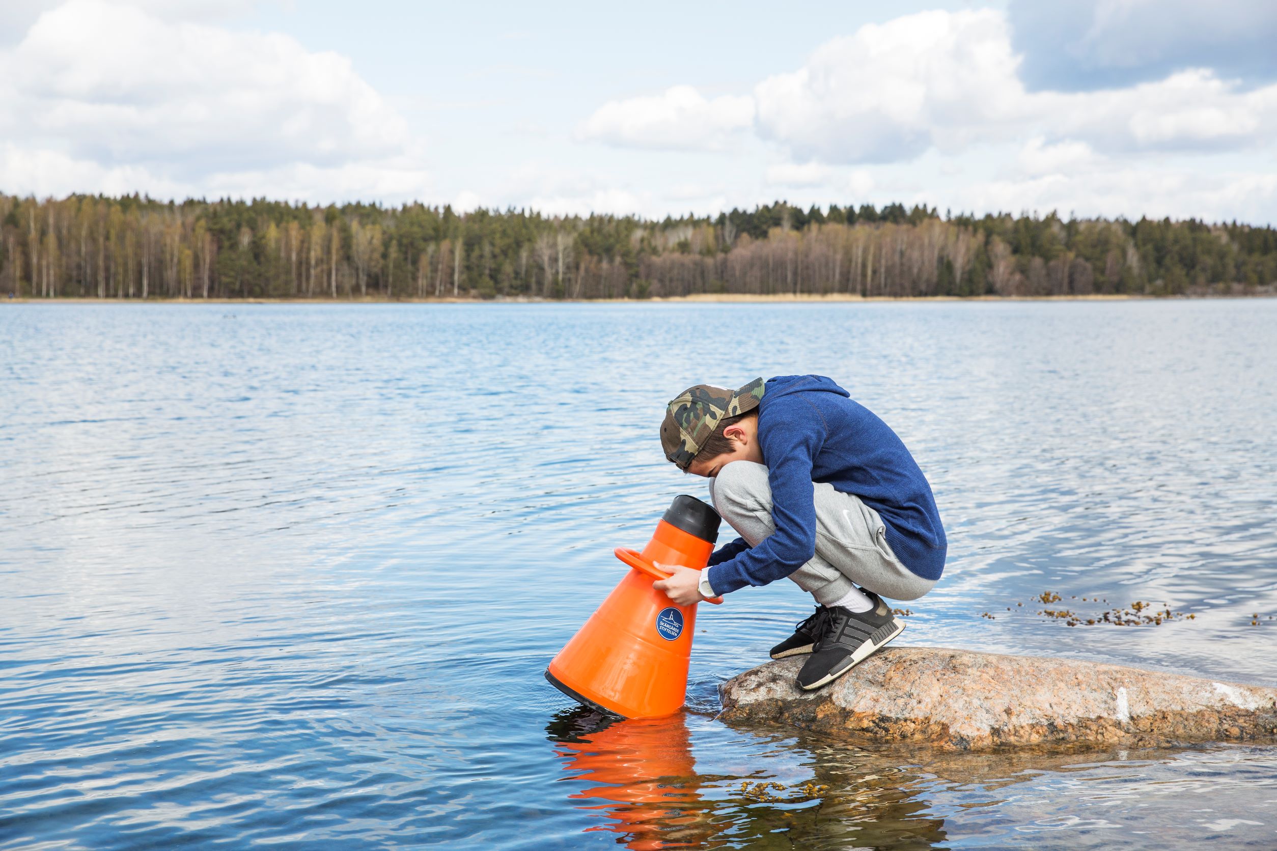 Pojke undersöker livet under vattenytan med en vattenkikare