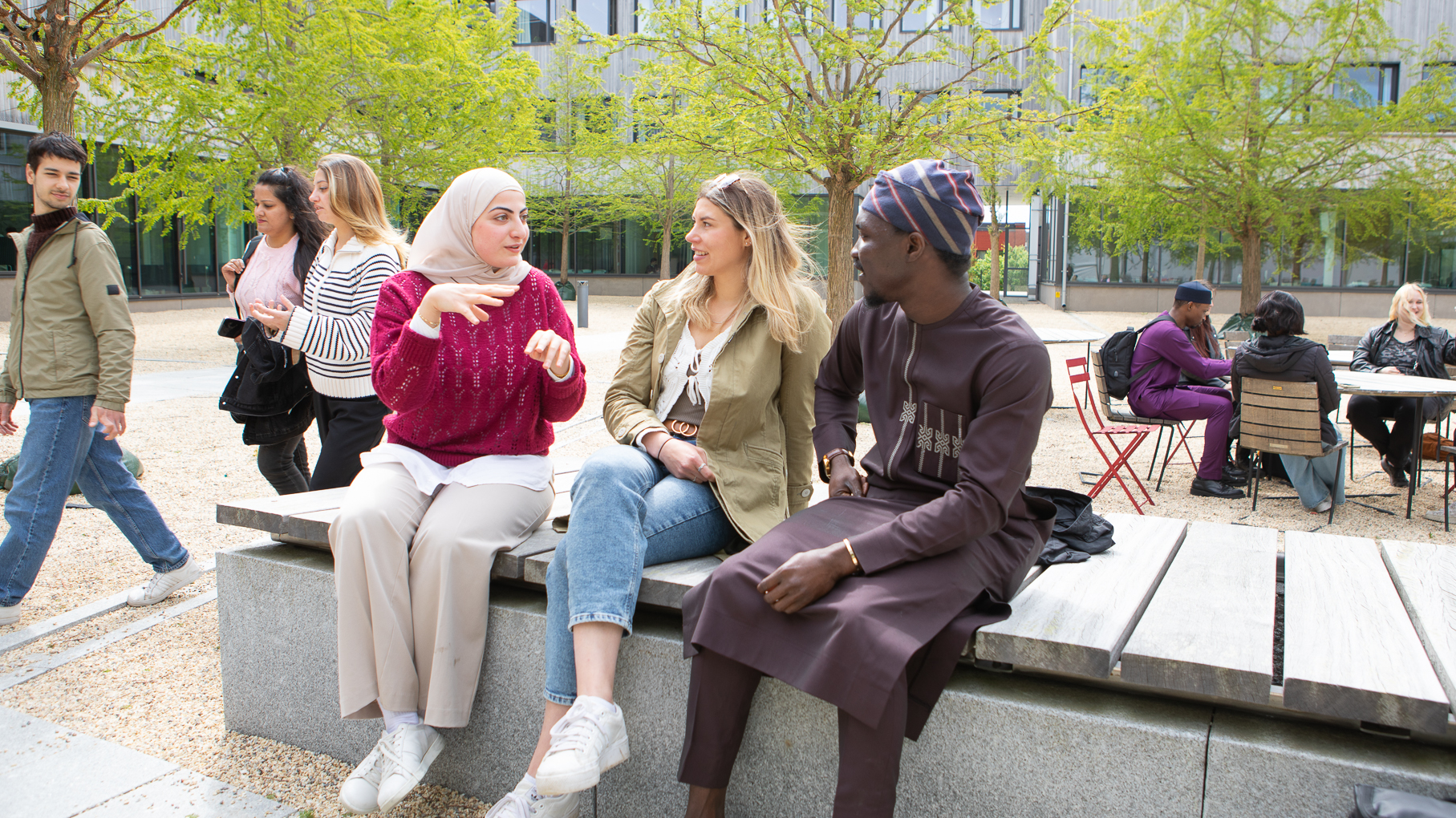 Grupp studenter som samtalar i en park.
