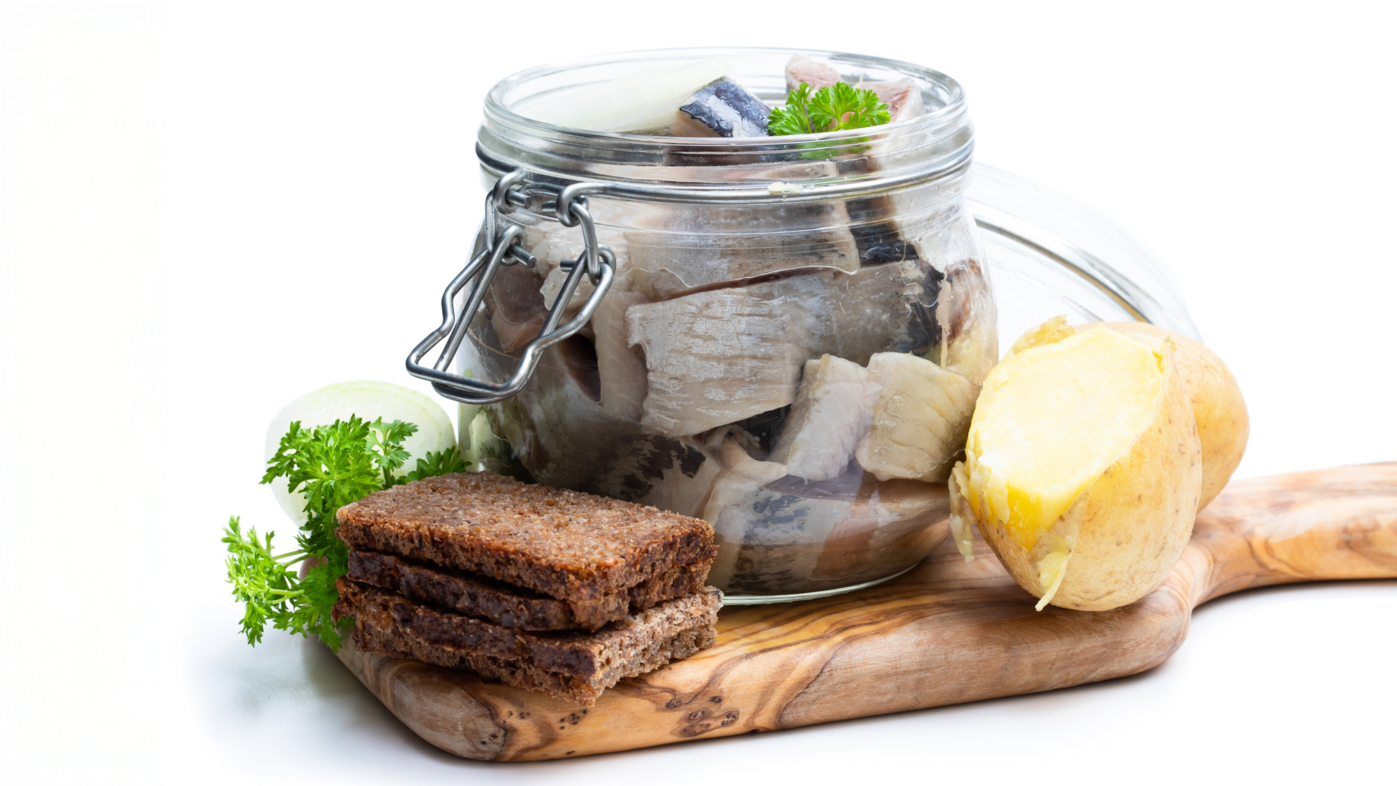 Bröd och en burk med sill på en skärbräda. Foto.