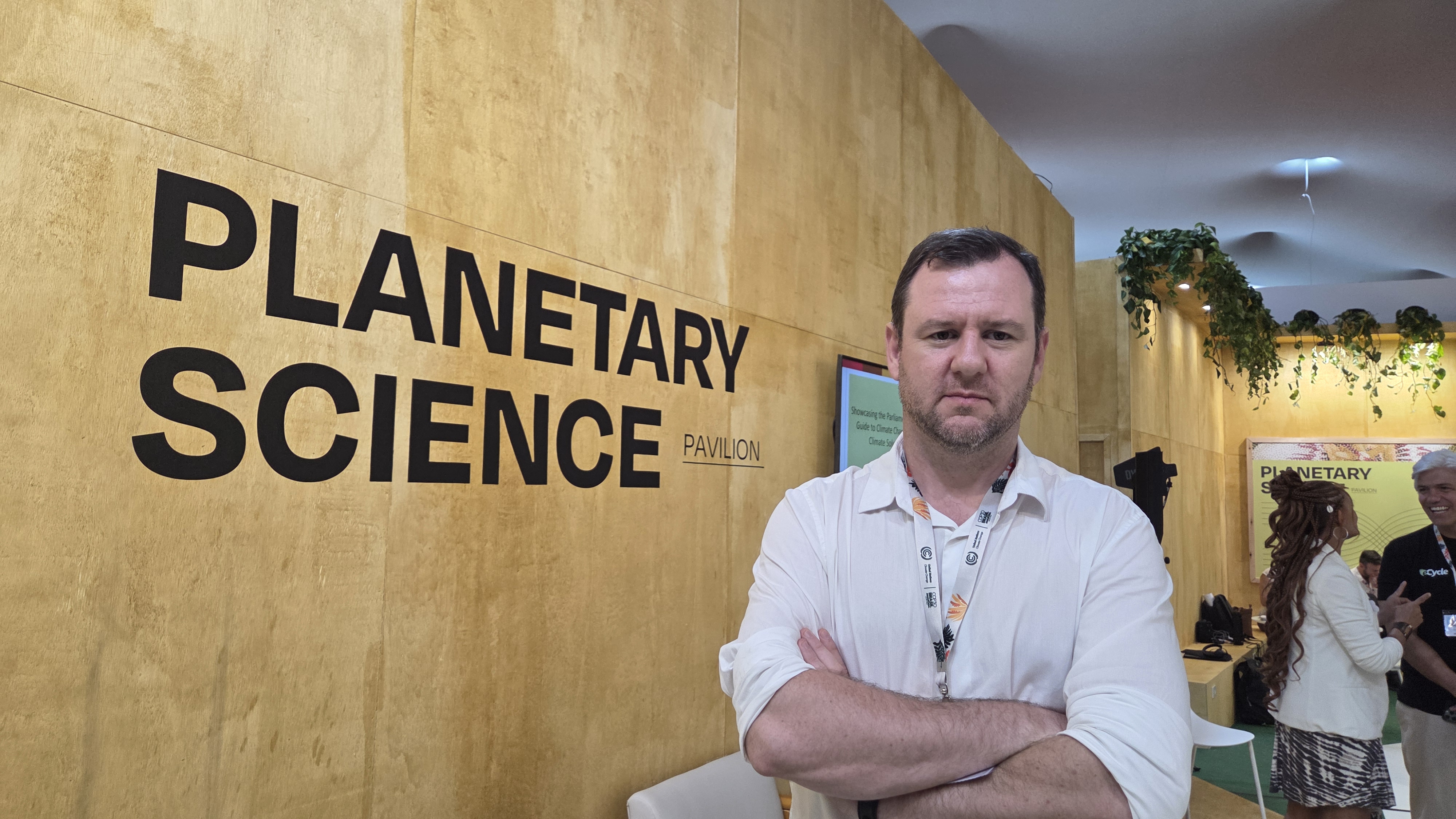 A man stands by a wall that says "Planetary science pavilion".
