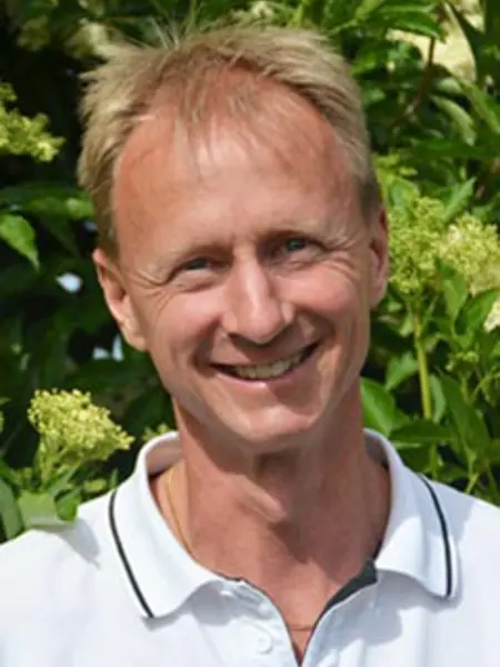 Porträttbild på David Johansson med blommande fläderbuske i bakgrunden. Foto.