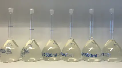 Six flasks of transparent liquid