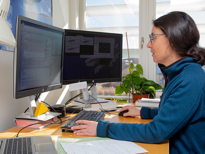 A woman sitting by a computer working.