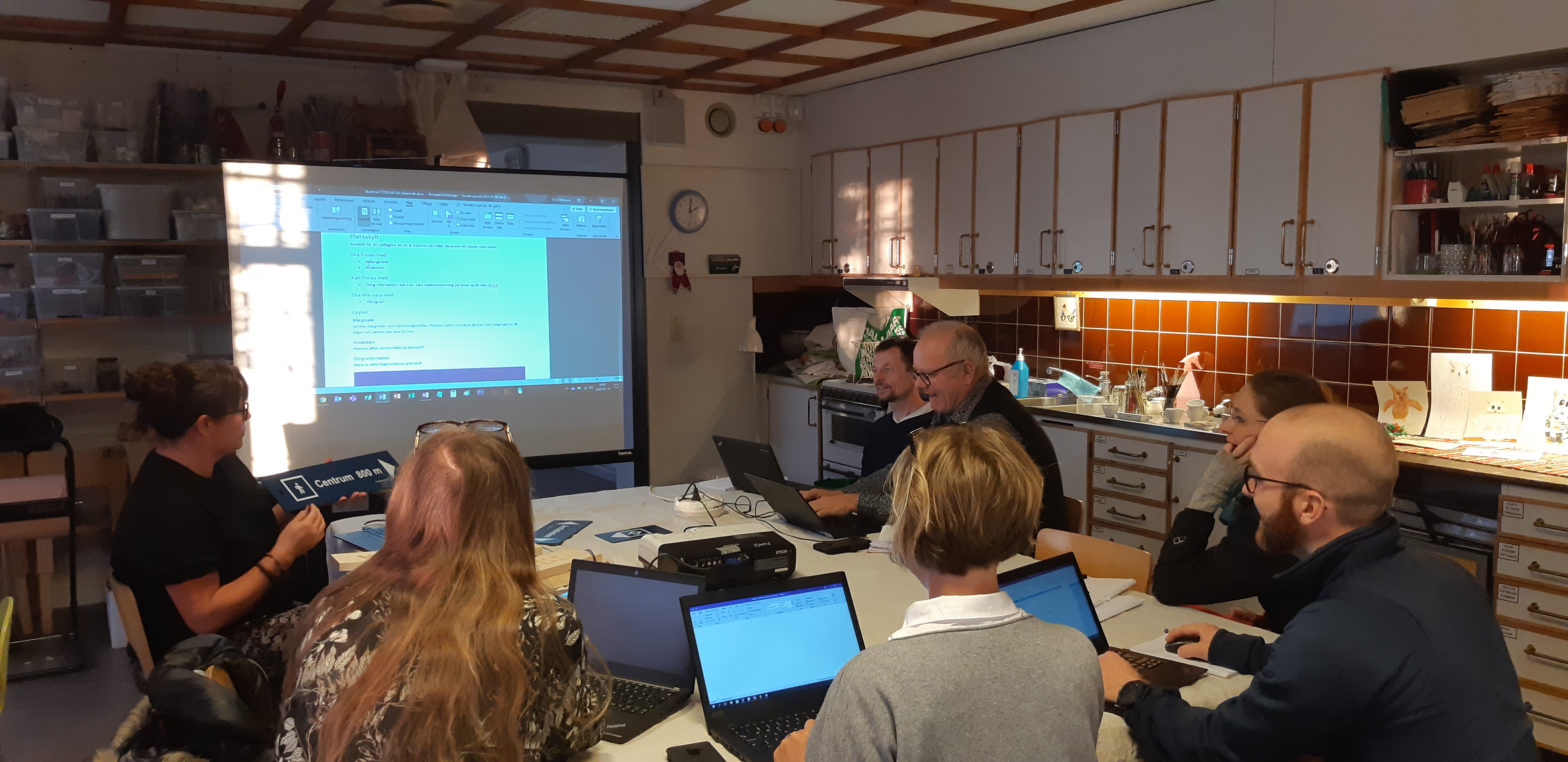 Personer sitter vid dator och bord