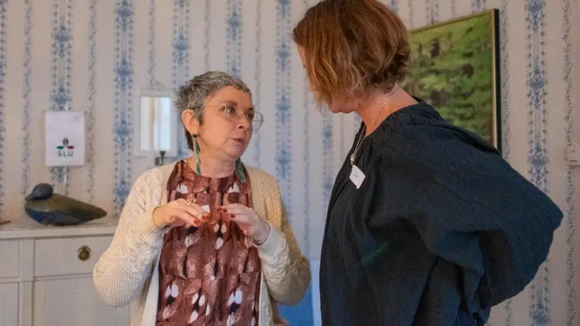 Två kvinnor pratar inomhus. Foto.