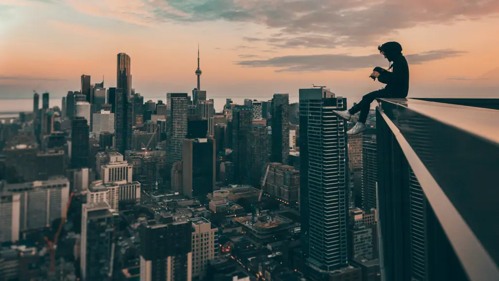Person on top of a skyscraper with view of the skyline