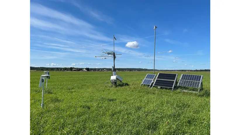 Five measuring instruments in different shapes placed in a field. Blue sky.