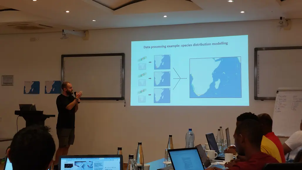 A person is standing in front of a powerpoint presentation