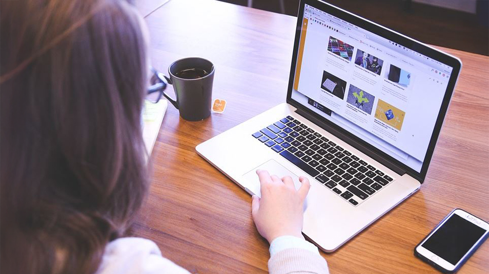 Student framför en bärbar dator