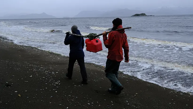 Forskare bär utrustning på stranden
