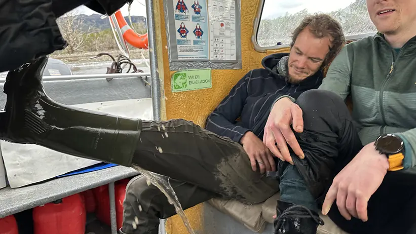 Forskare tömmer stövlarna på vatten ombord på båten.