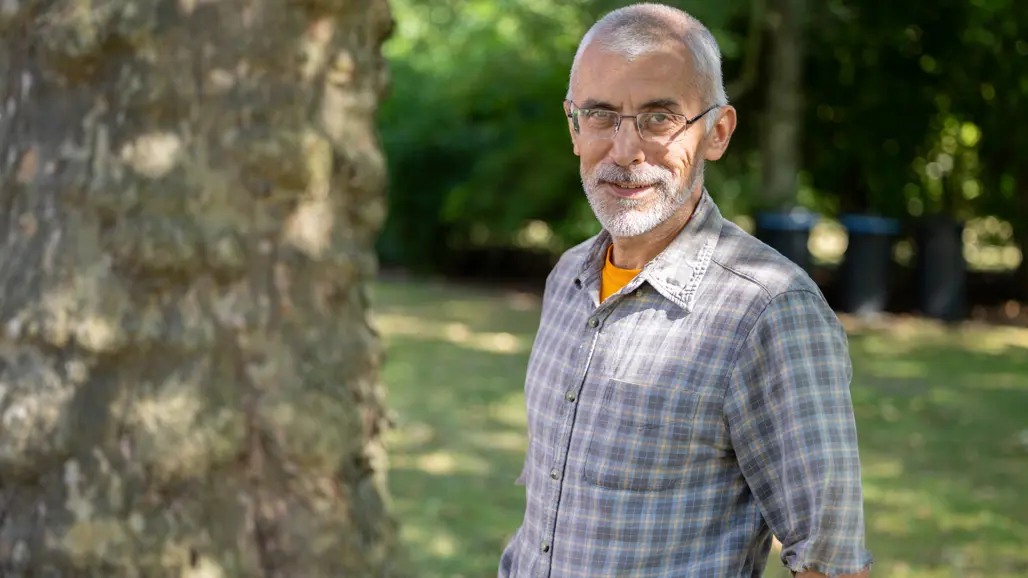 Man poserar framför ett träd