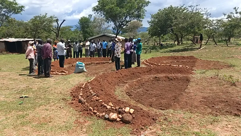 Francis Toroitich facilitates a practical field session on reseeding and halfmoons at the Kawoson Livestock Café site. Photo: S. Mureithi.