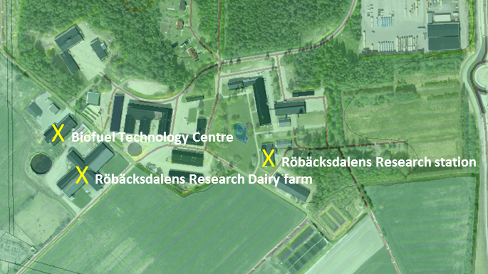 En satellitbild över ett område med flera byggnader och gröna fält. På kartan är tre platser markerade med gula "X": Biofuel Technology Centre, Röbäcksdalens Research Dairy farm och Röbäcksdalens Research station. Området omges av skog och åkermark.