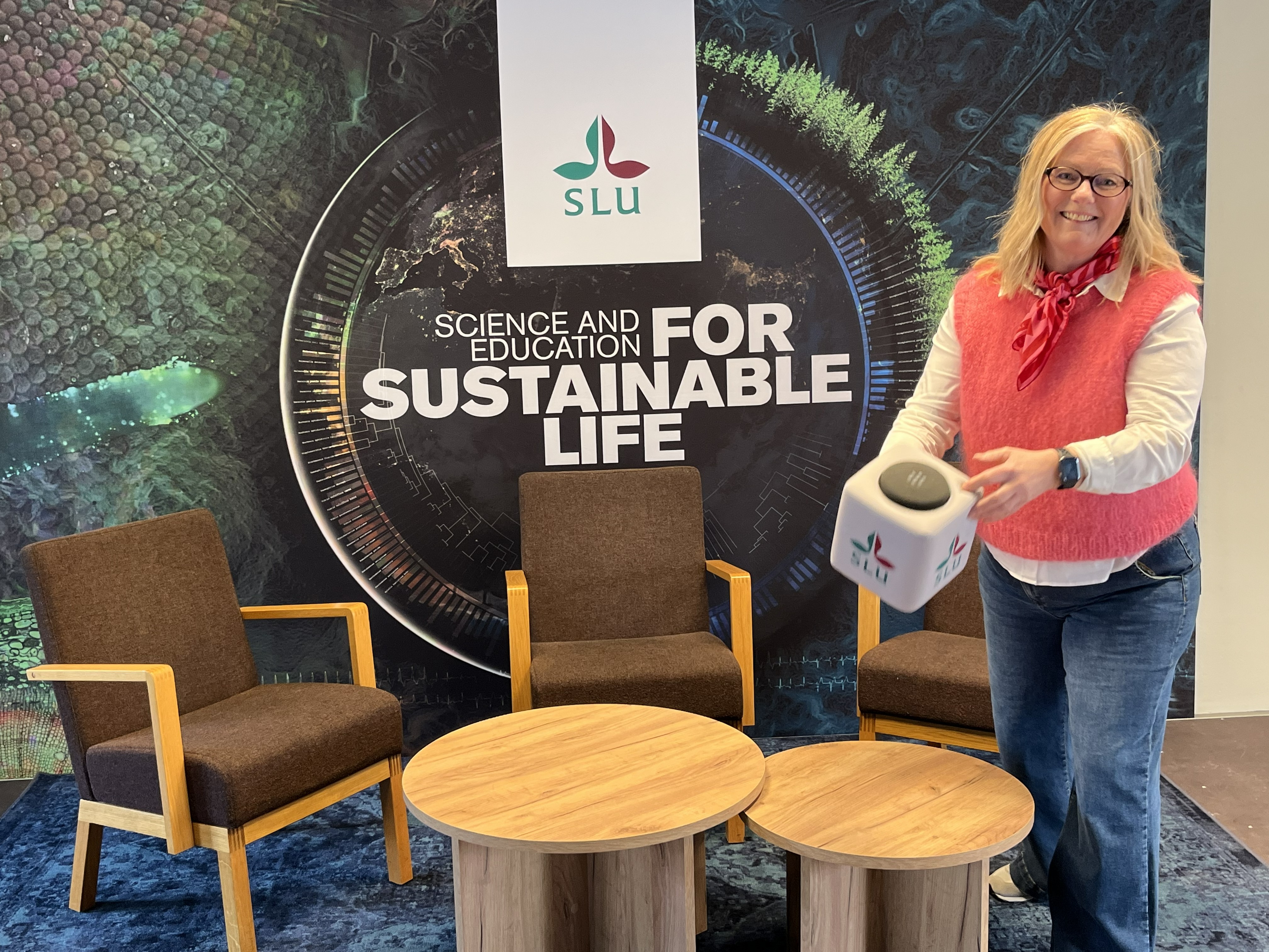 Marie står på scen och kastar ut en mikrofonkub till publiken