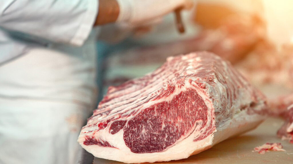 Närbild på en bit marmorerat kött på en skärbräda.