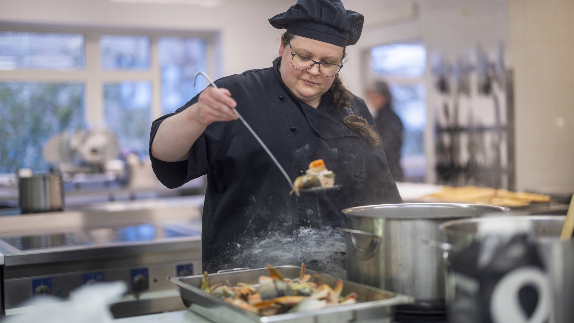 En måltidskock i offentligt kök lagar en gryta.