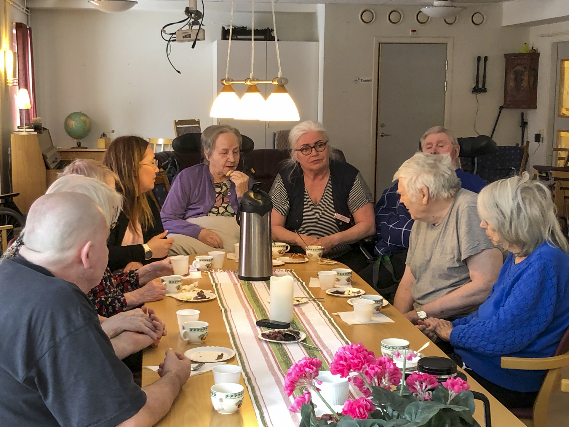 En grupp äldre sitter runt ett bord och äter.