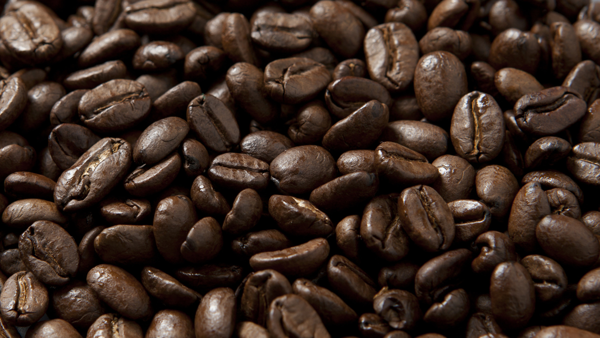 Närbild av en tät samling bruna kaffebönor.