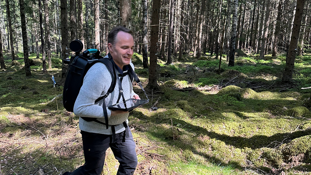 man springer med en ryggsäck i skogen