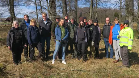 En grupp människor på naturbetesmark. Foto.