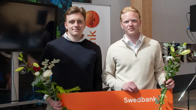 Två personer som håller i en jättestor check. Foto.