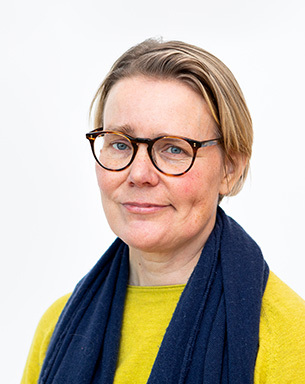 Porträttbild på Anna Skarin med gul tröja och en mörk sjal. Foto Jenny Svennås Gillner.