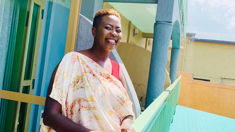 En leende kvinna på en balkong. Foto.