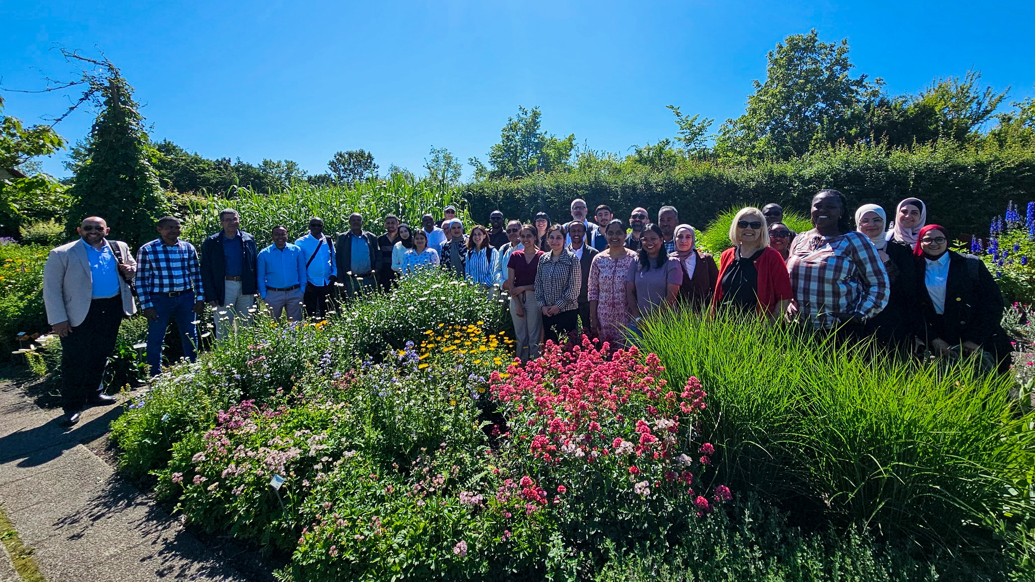 Group photo of many people in a garden.