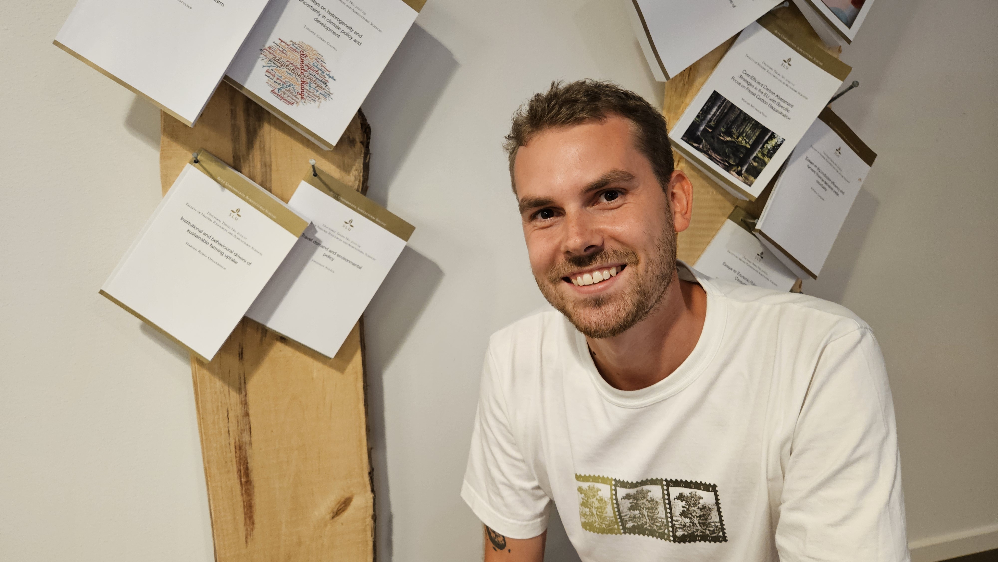 Doktoranden Harold Opdenbosch med sin uppspikade avhandling