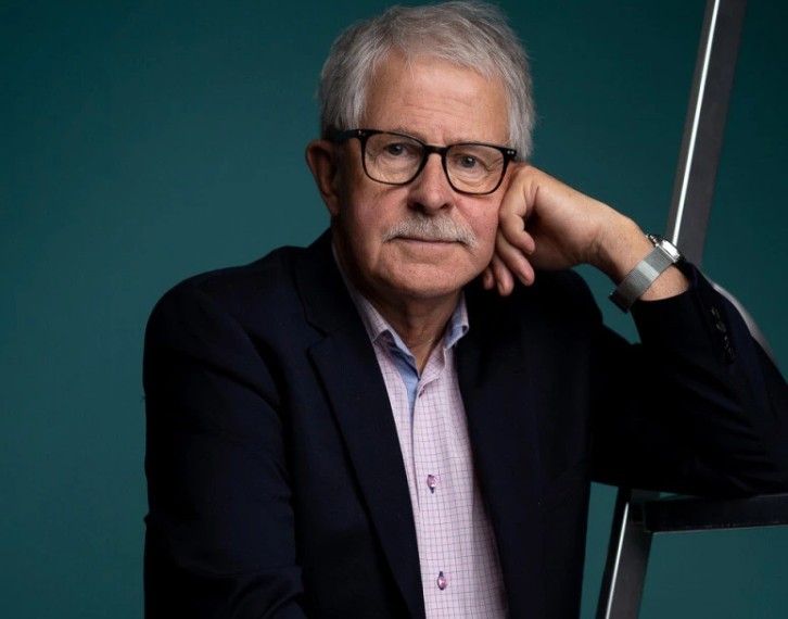 Äldre man med grått hår och glasögon. Foto