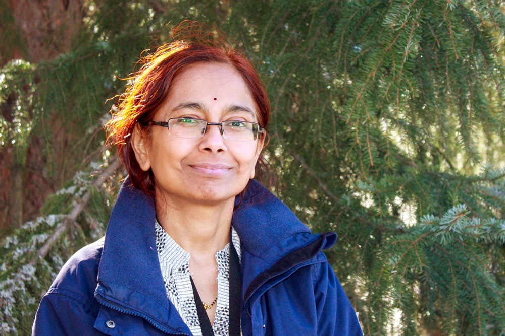 Picture of Sonali Ranade standing against a tree.