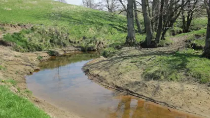 water course that meanders through a hilly agricultural landscape