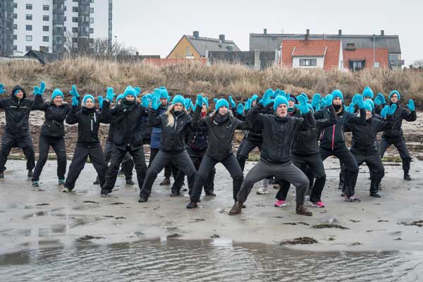 Studenter tolkar de stigande havsnivåerna som en dans vid havet i Höganäs. Foto: John S Webb. 