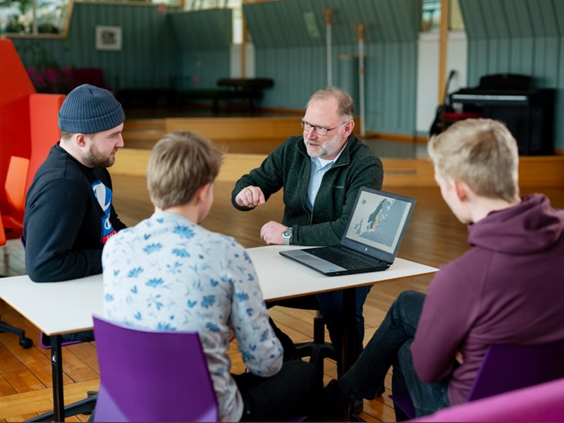Picture of Dag Fjeld in a conversation with some students.
