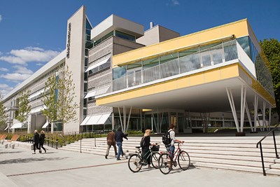 Två studenter leder sina cyklar utanför Biocentrum. Foto.