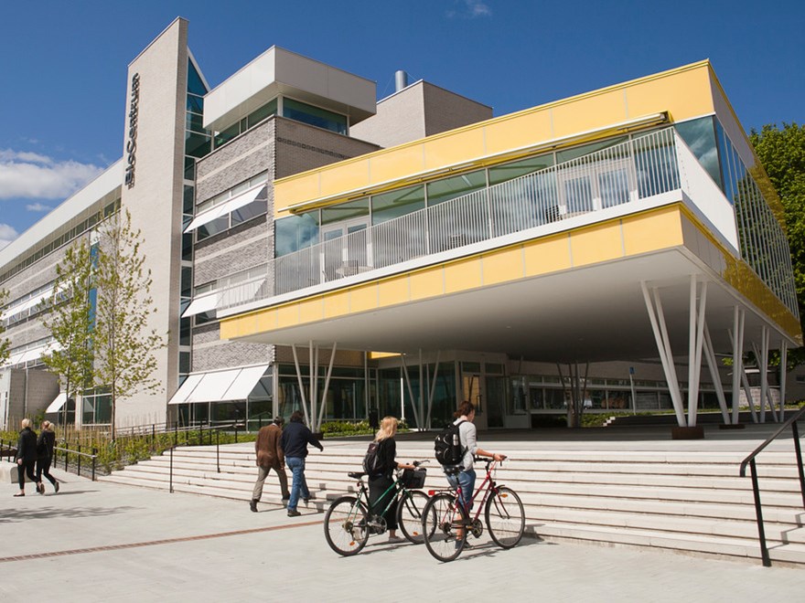 Buildings at campus. Students leading bicykles in front of the building. Photo: Jenny Svennås-Gillner, SLU