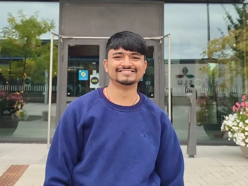 An image of a man standing in front of a building.