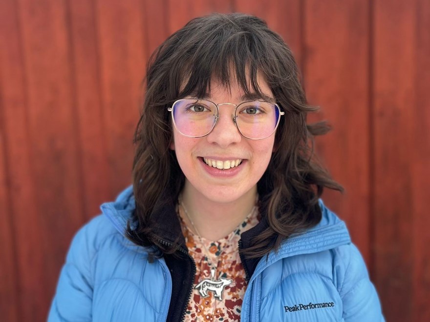 An image of a woman. She's smiling at the camera and wears a winter jacket.