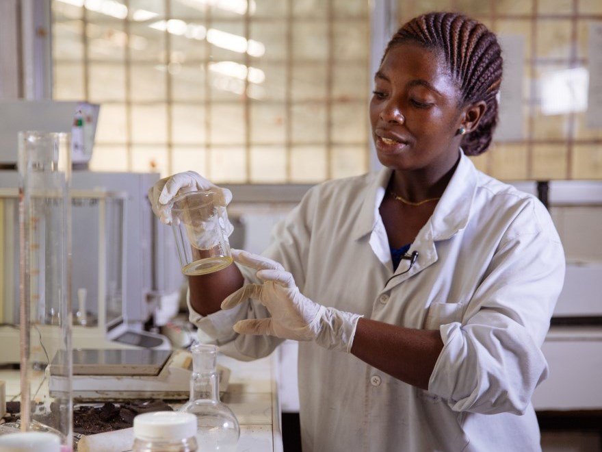 Chemist examining a beaker at a crude oil processing lab in Arusha, Tanzania