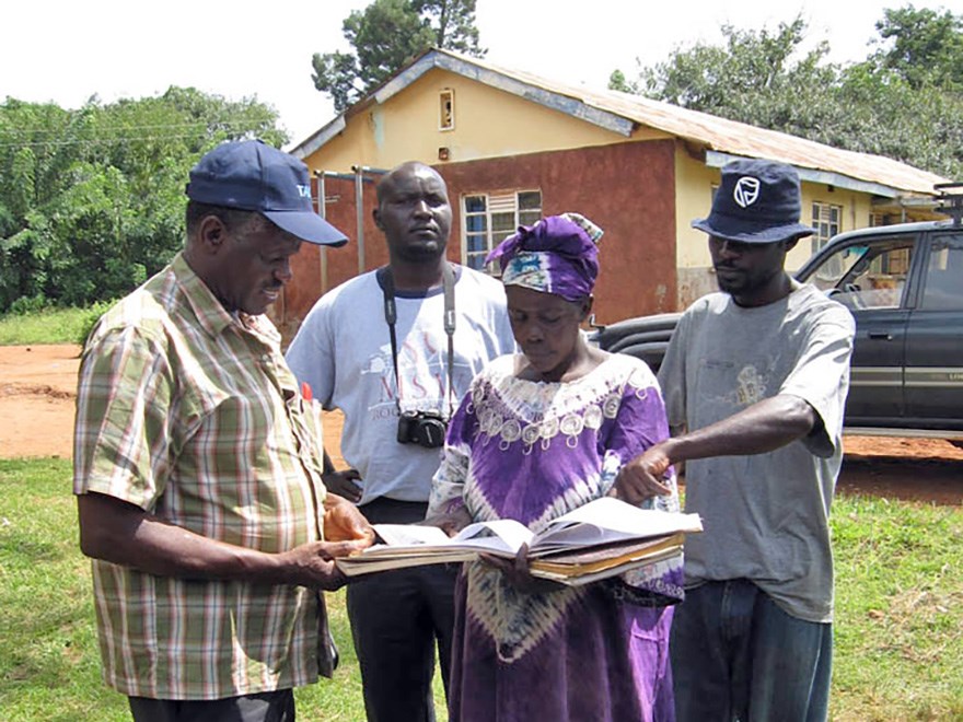 Four people discussing outside a house, photo.