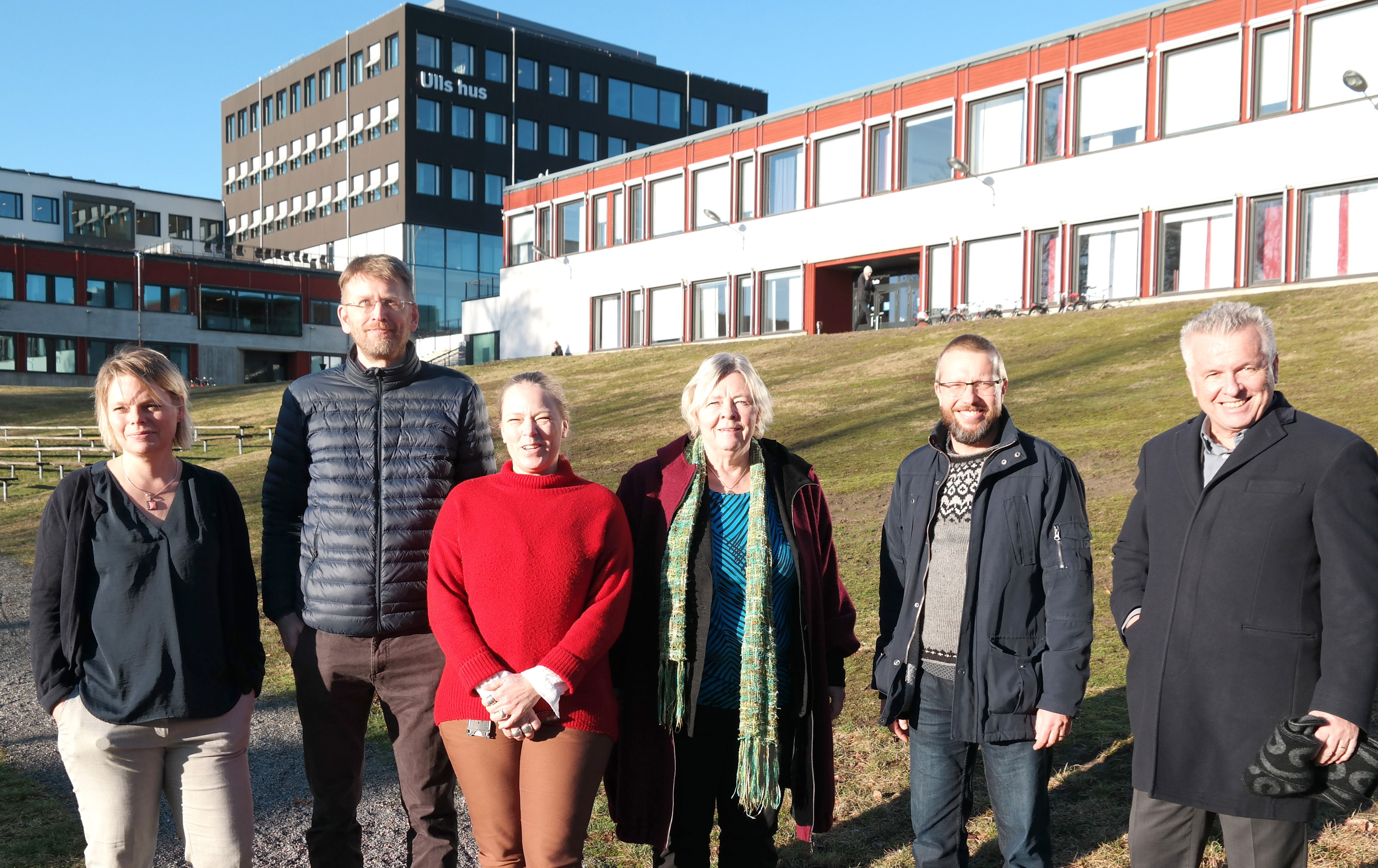 A group of people standing in front of buildings. Photo.