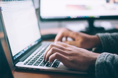 A person writes on a computer