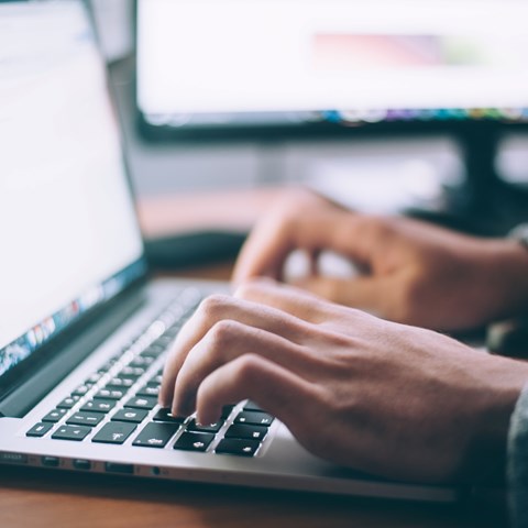 A person writes on a computer