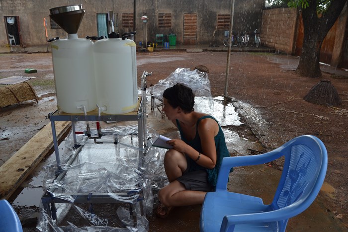 A female researcher is testing a rainfall simulator