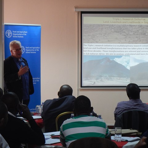 A facilitator is showing a presentation slide to an audience in Nairobi.