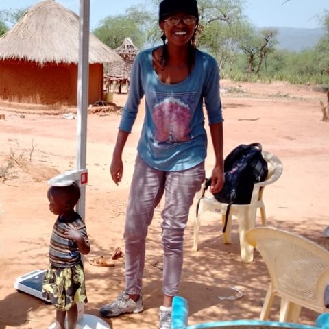 Woman measures height of a young child in Kenya